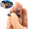 A hand holds an adjustable soft lure fishing tackle, featuring a shiny, dark body and iridescent speckles.