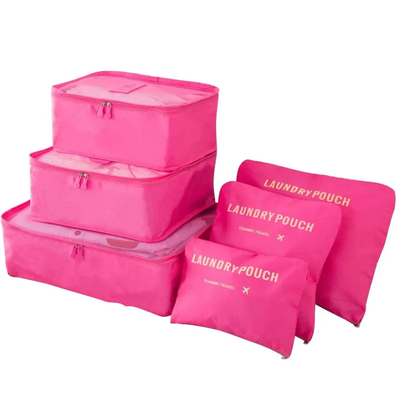 A set of pink laundry pouches and packing cubes for travel organization.