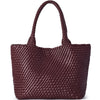A dark burgundy handwoven vegan leather tote bag with a woven texture.