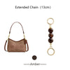 A brown suede pouch attached to an extended gold chain with dark amber beads.