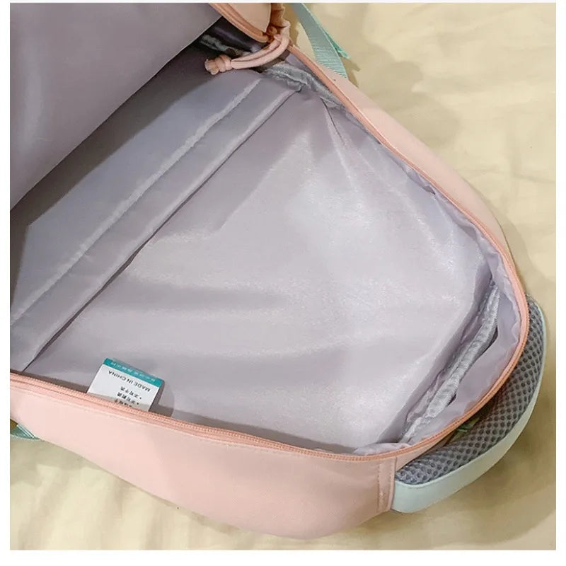 A pink and gray fabric backpack is shown open, displaying the interior lining.