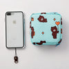 A light blue fabric pouch with a pattern of cute brown bears and orange hearts, next to an iPhone.