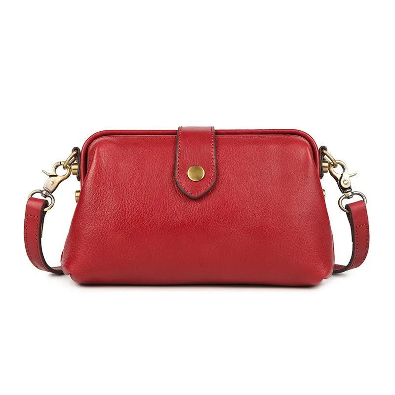 A red genuine leather crossbody bag with a gold-toned buckle closure.