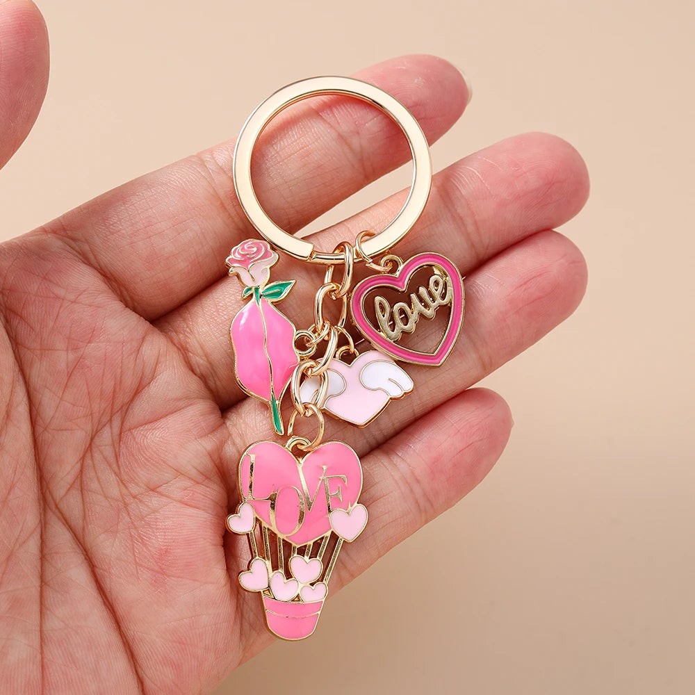 A gold-toned enamel heart keychain featuring a rose, a love heart, and a heart balloon.