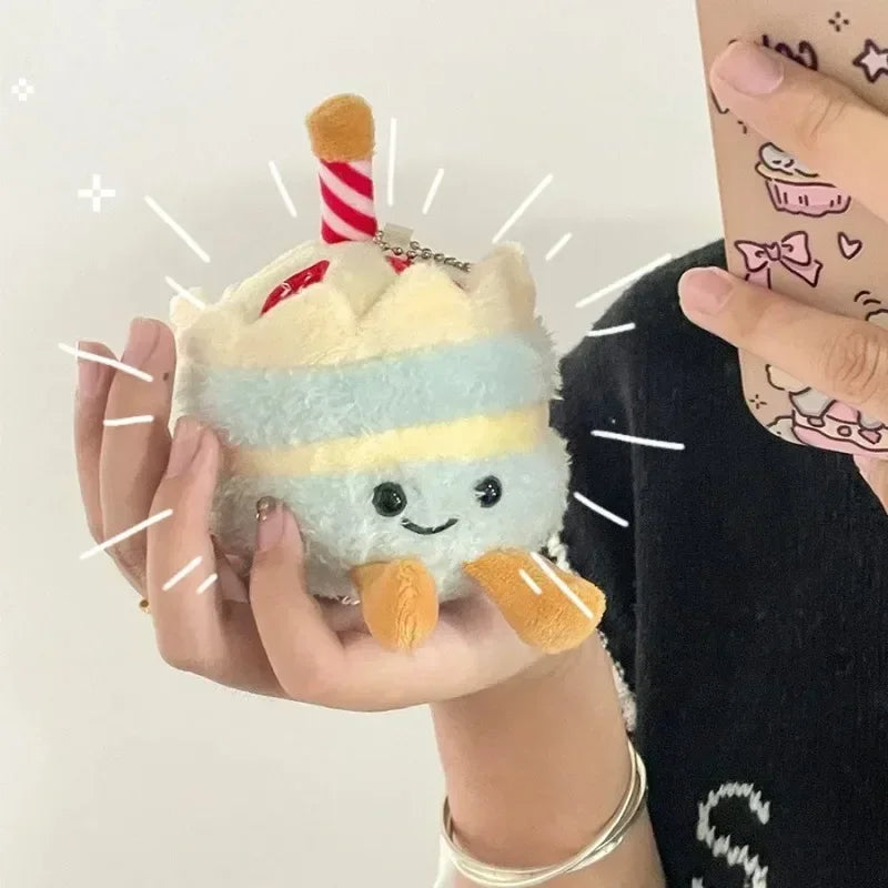 A fluffy, light blue and yellow bread-shaped plush keychain with a striped orange stick attached.