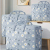 A stack of light blue fabric storage bags patterned with white daisies and green leaves.