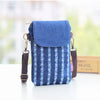 A blue denim mini messenger bag with a flap and strap is shown on a white surface.