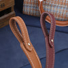Raccord en cuir marron avec boucle laiton, utilisé comme sangle de sac à l'épaule ajustable.