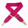 A magenta canvas cotton bag strap with gold-toned metal hooks shown in an X-shape.