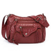 A deep red leather tote bag with multiple pockets and a strap is shown against a white background.