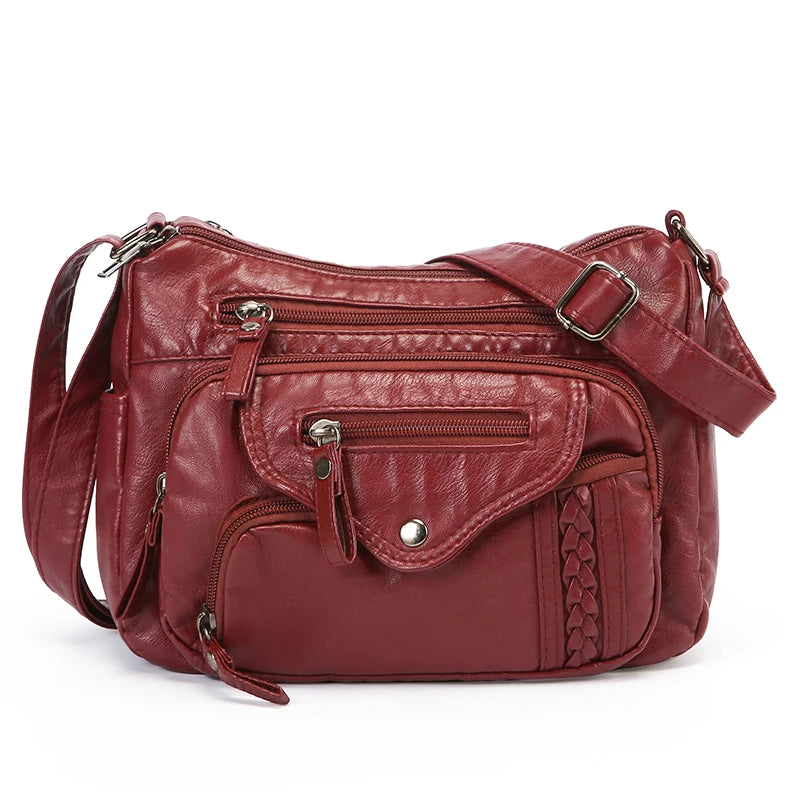 A deep red leather tote bag with multiple pockets and a strap is shown against a white background.