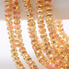 A close-up of strands of yellow and orange faceted crystal glass beads for jewelry making