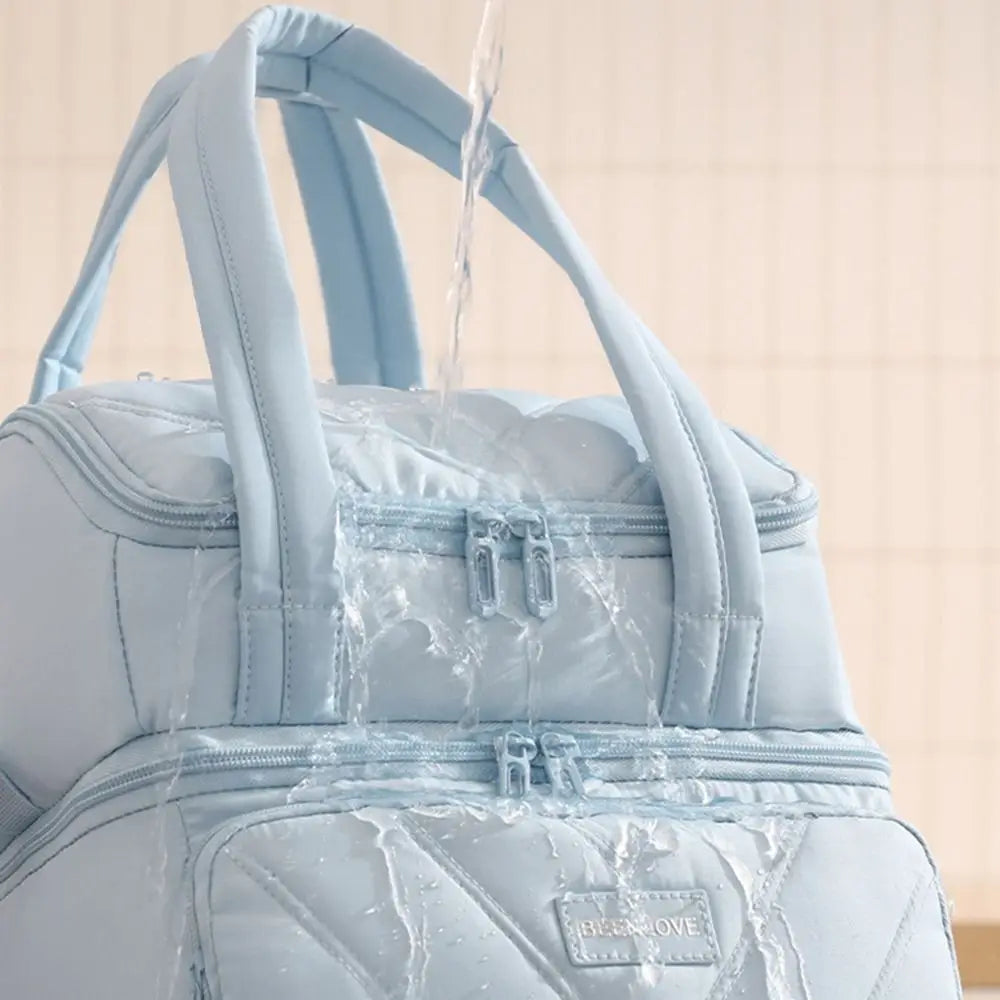 Una bolsa de almuerzo aislada azul claro con agua goteando sobre ella.