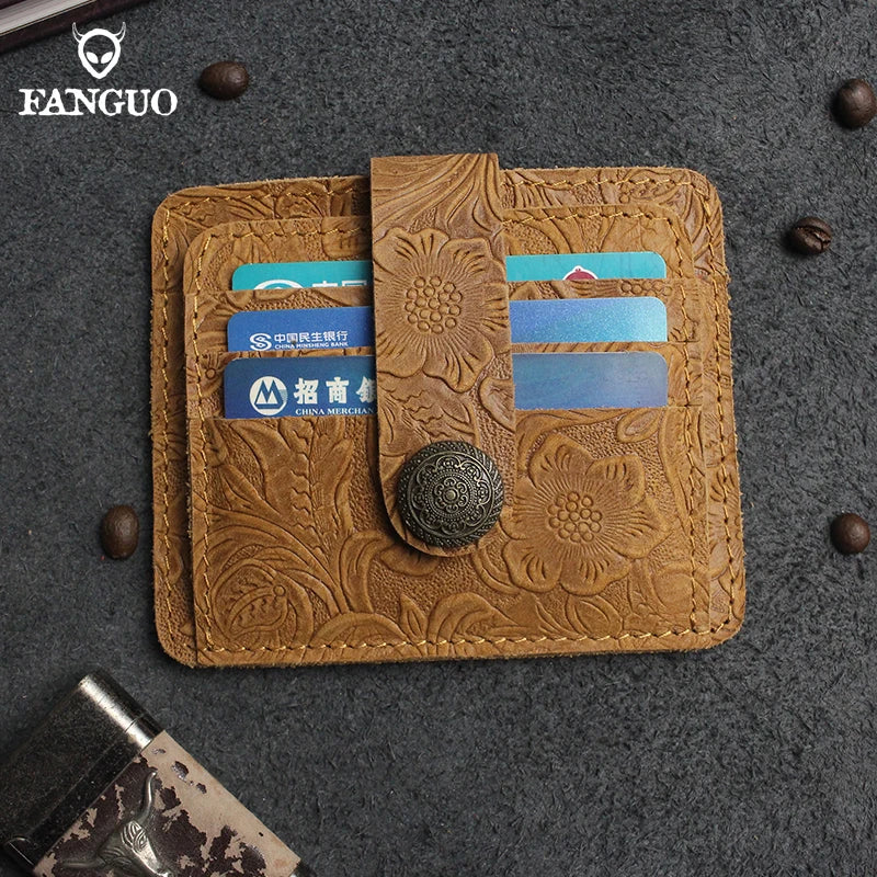 A brown genuine leather card wallet with embossed floral patterns and multiple slots for cards is displayed on a dark gray su