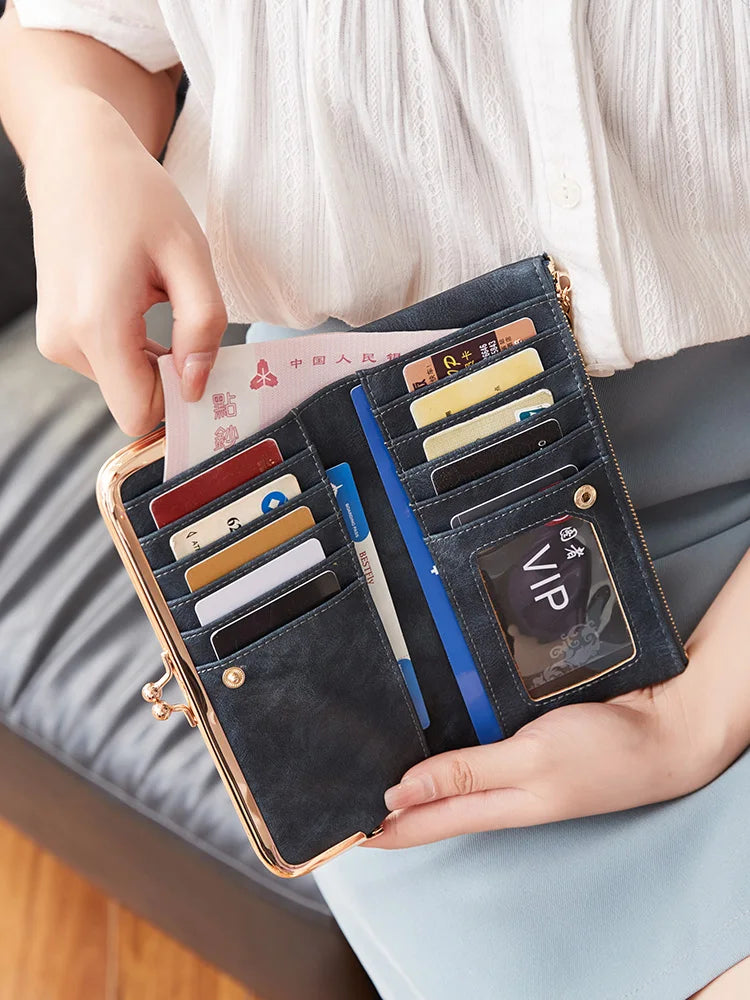 Eine Hand hält eine schwarze Lederclutch mit Kreditkarten und einem Ausweis.