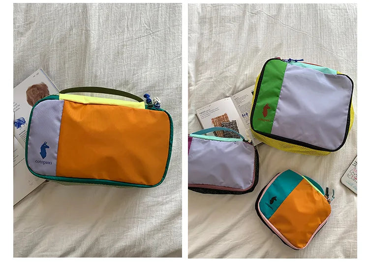 Two waterproof travel toiletry bags in purple, orange, and lime green nylon construction lying on a white sheet.