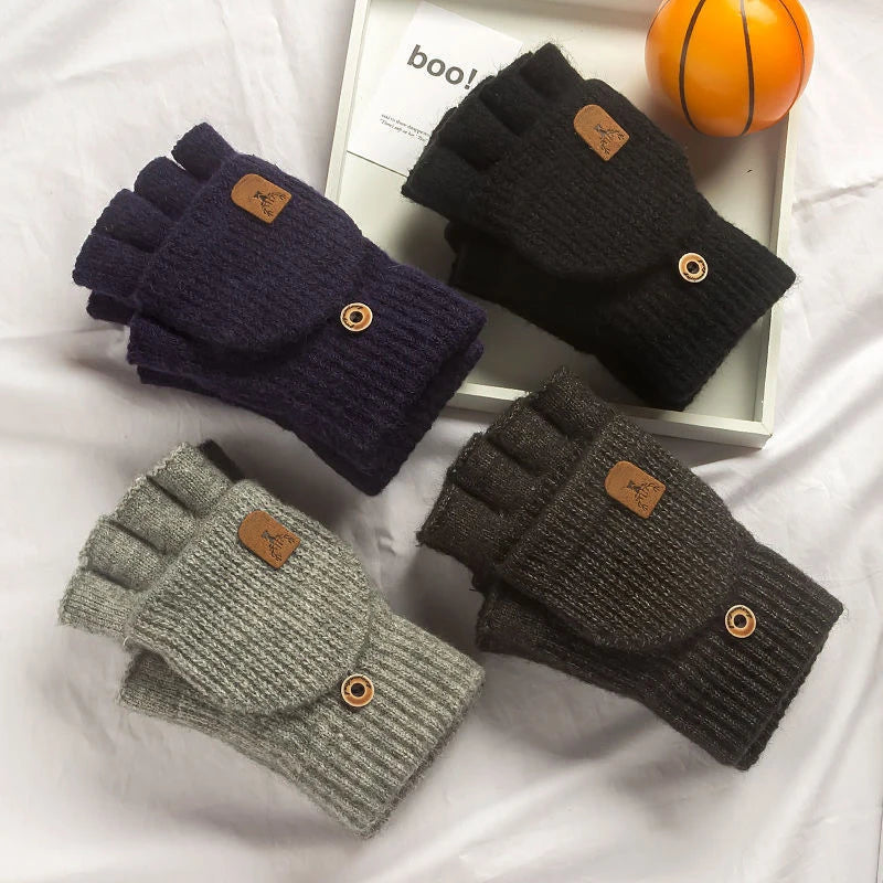 Eine Sammlung warmer, gestrickter Fingerlose Handschuhe in Dunkelviolett, Schwarz und Grau neben einer orangen Kugel.