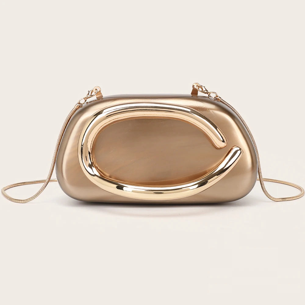 A smooth, gold-tone evening clutch bag with a curved design and thin gold chain strap.