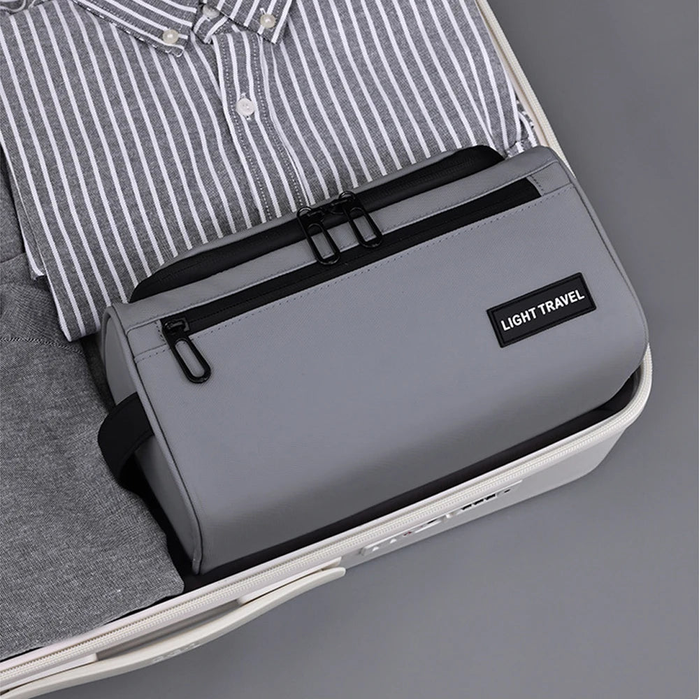 A gray travel toiletry bag is shown inside a white case, next to a striped shirt.