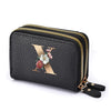 Black mini wallet with a gold letter X and floral accents featuring a double zipper closure