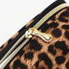 Close-up of a leopard print cosmetic organizer bag featuring a gold zipper detail.