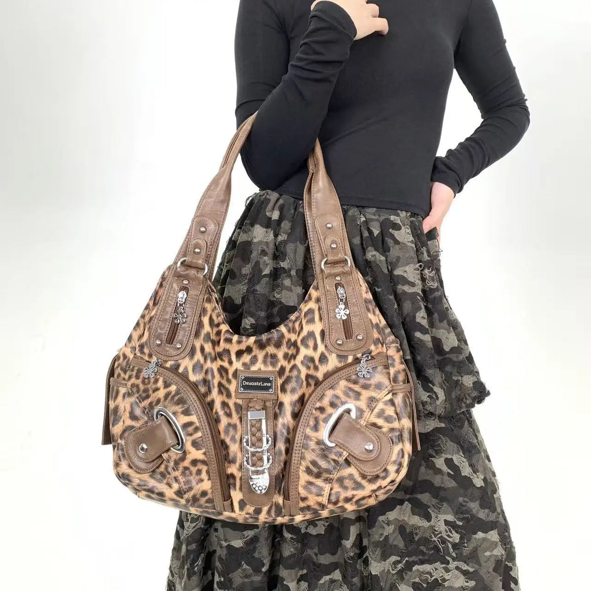 A brown leopard print crossbody shoulder bag worn by a person, set against a light background.