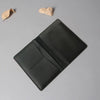 A dark gray genuine cowhide leather passport and ticket holder with a folded design.