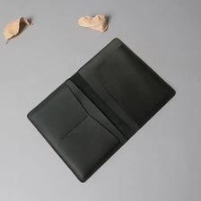Porte-passeport et porte-billet en cuir de vachette gris foncé avec conception pliée.
