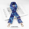 A dark blue and teal patterned nylon bag strap is displayed on a white box.