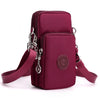 A deep magenta nylon crossbody phone bag with a silver clasp and adjustable strap.