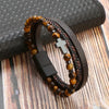 A men's multi-layer leather bracelet featuring dark brown and amber tiger eye beads on a black leather band.