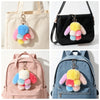 A black handbag featuring a cute plush rabbit charm with a colorful pom-pom and keyring.