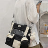 A white long-sleeved shirt is worn by a person holding a black and beige Kawaii Harajuku backpack with a laptop compartment.