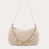A beige straw shoulder bag with gold hardware and small ocean charms