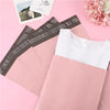 Bolsas adhesivas rosas para almacenamiento y envío, mostradas sobre un fondo rosa.