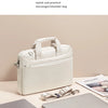 A white messenger/shoulder bag is shown next to a silver laptop sleeve.