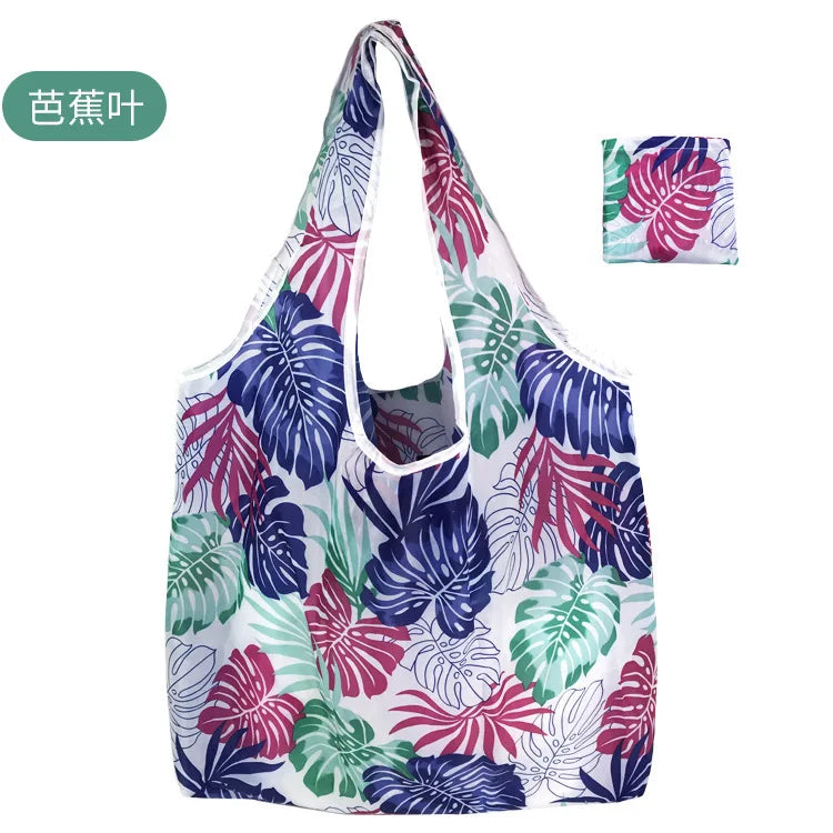 A reusable eco tote shopping bag featuring a vibrant floral pattern with shades of purple, pink, and green.