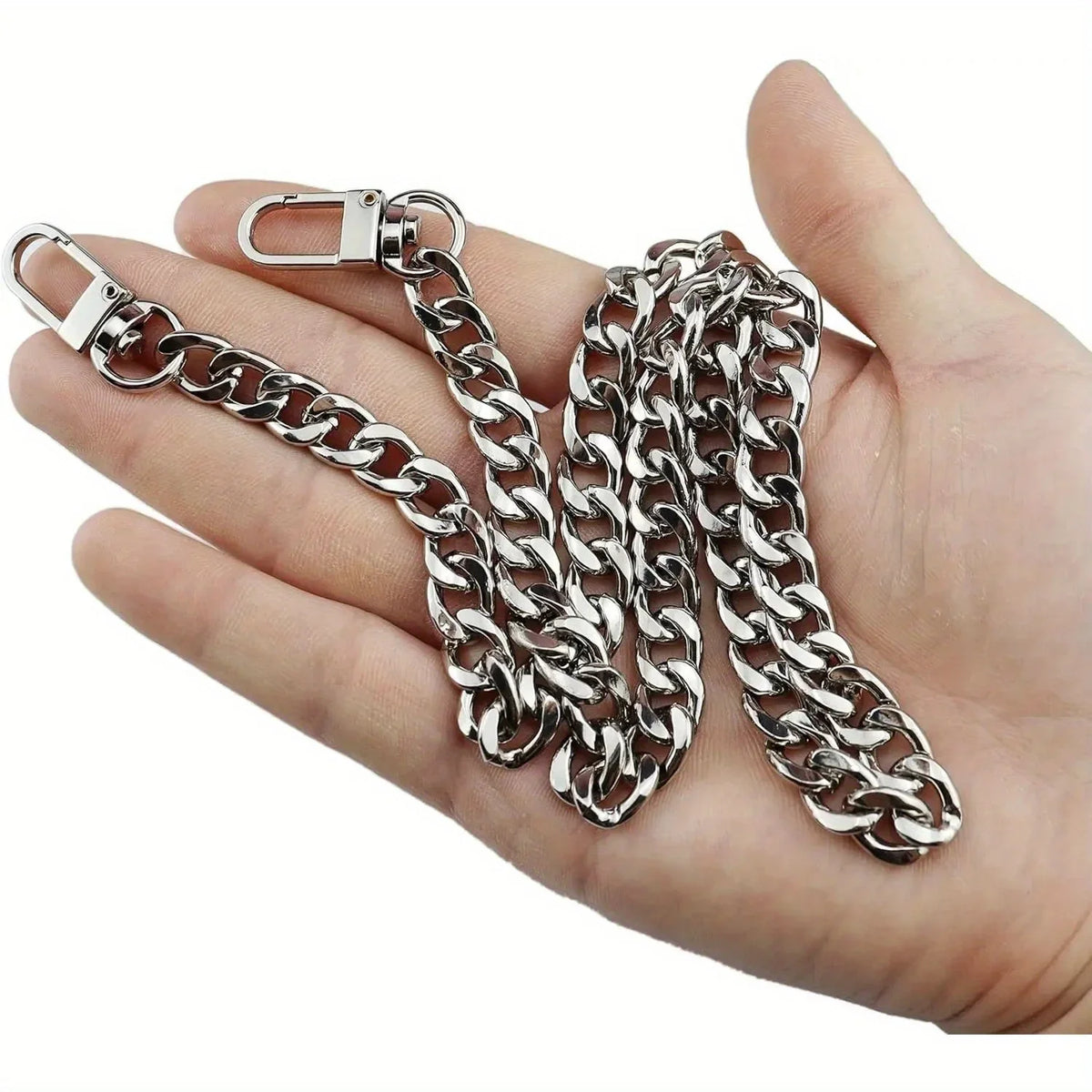 Silver metal chain strap with a clasp is held in a hand.