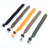 Five handwoven paracord camera wrist straps in black, brown, orange, olive green, and dark green.