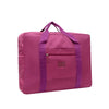 A magenta foldable travel duffel bag with a purple strap and pocket.