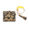 A silicone bead bracelet and a leather card holder with a sunflower print cover are displayed together.
