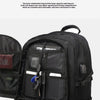 A close-up view of a black durable travel backpack showing various zippered compartments and pockets.