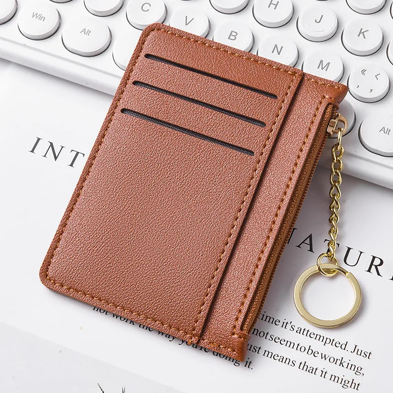Braunes Leder-Klemmwallet mit Reißverschluss auf einer weißen Tastatur.