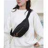A woman wearing a white sweater holds a black quilted nylon crossbody belt bag.