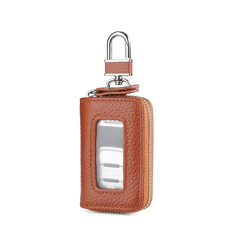 A brown leather car key case with a transparent window and a silver hook.