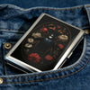 A silver metal card holder with an intricate floral design is shown inside a blue denim jean pocket.
