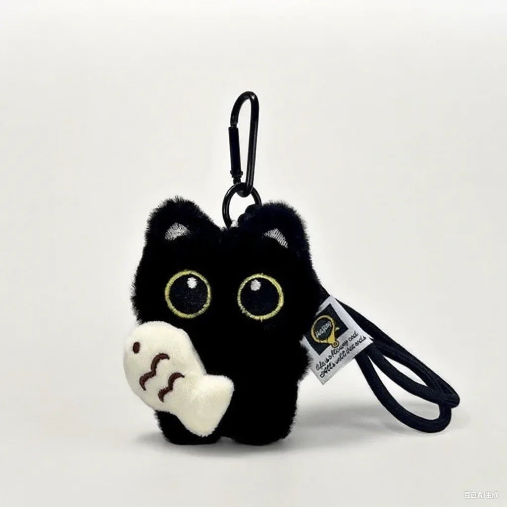 A black cat plush keychain featuring large yellow eyes and a white nose, attached to a black cord.