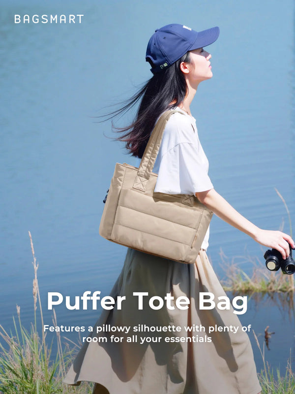 Eine Frau in einem leichten Oberteil und einem langen Rock hält eine beige gesteppte Puffer-Tasche im Freien.
