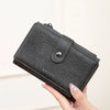 A black leather clutch wallet with silver accents is held by a hand, showing the interior card slots.