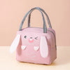 A pink cartoon insulated lunch bag featuring a smiling duck face and a small dove design.